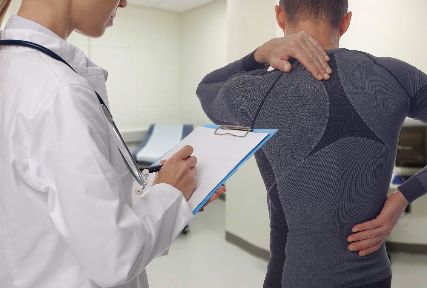 A doctor examining a patient's back
