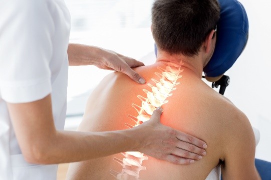 A person receiving a back adjustment with an overlay of the spine