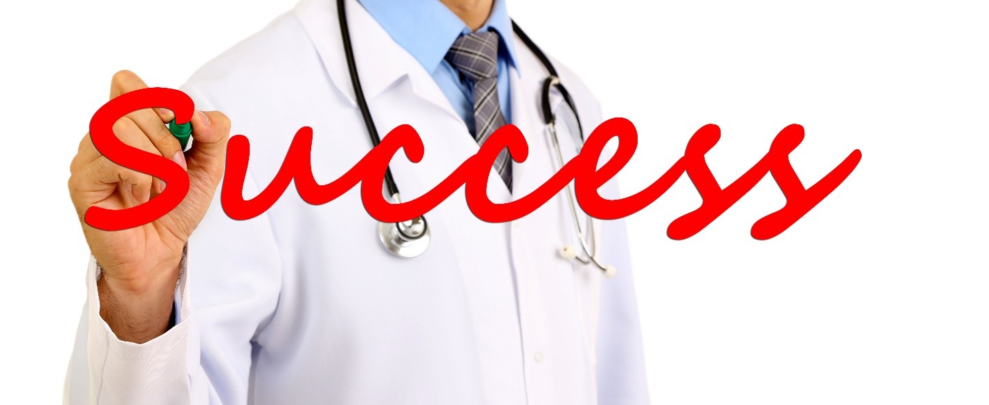 A doctor writing the word Success in red marker on a transparent surface