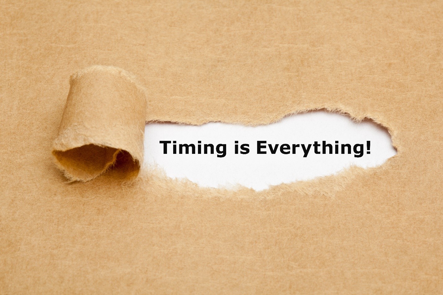 Torn paper revealing the text Timing is Everything