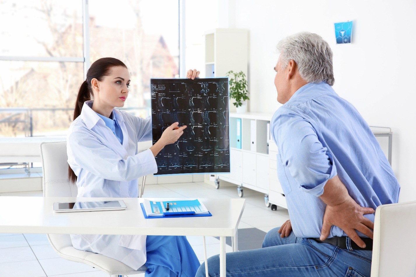 Doctor reviewing a spine X-ray with a patient